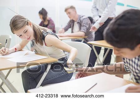 Students passing note between desks during their GCSE exam View Large Photo Image Stock Photo - Students passing note between desks during their GCSE exam. Fotosearch