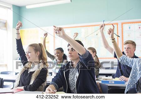 Students raising arms during lesson in classroom View Large Photo Image Stock Image - Students raising arms during lesson in classroom. Fotosearch
