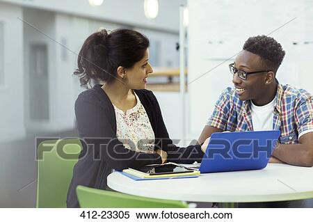 Teacher and student sitting together with laptop and tablet View Large Photo Image Stock Photography - Teacher and student sitting together with laptop and tablet. Fotosearch