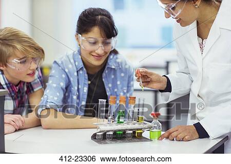 Teacher and students during chemistry lesson, wearing protective eyewear and looking at test tubes View Large Photo Image Stock Photograph - Teacher and students during chemistry lesson, wearing protective eyewear and looking at test tubes. Fotosearch