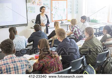 Stock Image - Teacher and students in classroom during lesson. Fotosearch