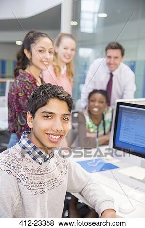 Teacher and students posing during IT lesson View Large Photo Image Stock Photo - Teacher and students posing during IT lesson. Fotosearch