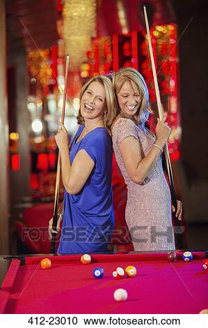 Two mature women laughing and playing pool in nightclub View Large Photo Image Stock Image - Two mature women laughing and playing pool in nightclub. Fotosearch