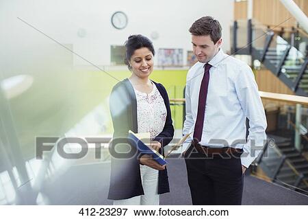 Two smiling teachers talking in corridor in high school View Large Photo Image Stock Photo - Two smiling teachers talking in corridor in high school. Fotosearch