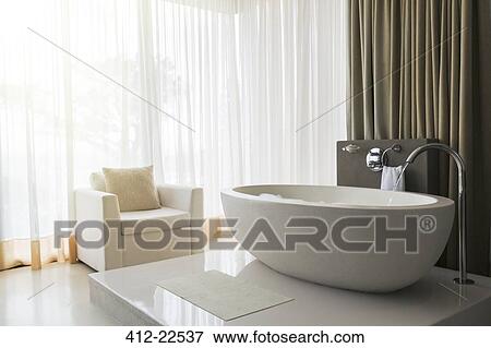 View of modern and luxurious bathroom with bathtub and armchair View Large Photo Image Stock Photo - View of modern and luxurious bathroom with bathtub and armchair. Fotosearch