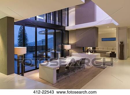 View of modern dining room with large table and chairs at night View Large Photo Image Stock Image - View of modern dining room with large table and chairs at night. Fotosearch