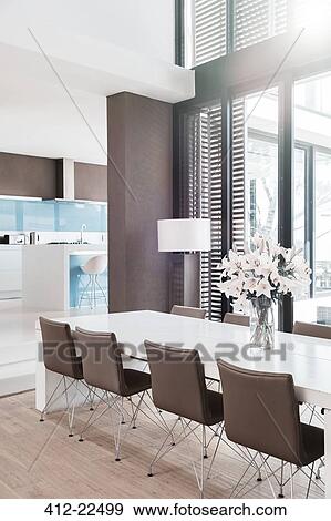 View of modern dining room with white lilies in vase on table View Large Photo Image Stock Photo - View of modern dining room with white lilies in vase on table. Fotosearch