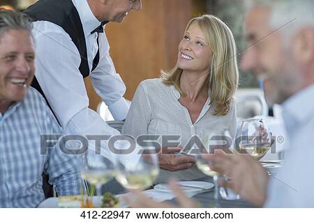 Waiter serving food to woman in restaurant View Large Photo Image Stock Photo - Waiter serving food to woman in restaurant. Fotosearch
