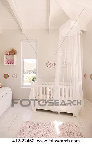 White Crib With Tulle Canopy In Pastel Colored Baby S Room Stock