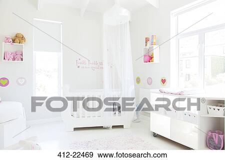 White Crib With Tulle Canopy In Pastel Colored Baby S Room Stock