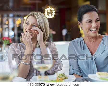 Women laughing at table in restaurant View Large Photo Image Stock Image - Women laughing at table in restaurant. Fotosearch