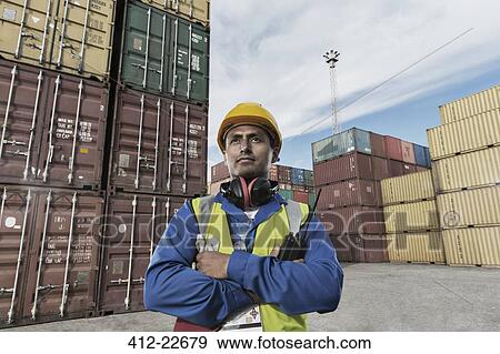 Worker standing near cargo containers View Large Photo Image Stock Photo - Worker standing near cargo containers. Fotosearch