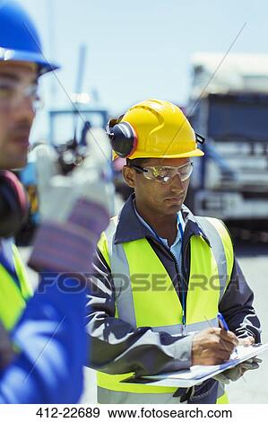 Worker writing on clipboard View Large Photo Image Stock Photo - Worker writing on clipboard. Fotosearch