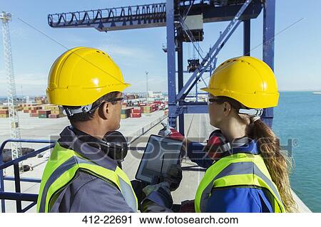 Workers using digital tablet on cargo crane View Large Photo Image Stock Image - Workers using digital tablet on cargo crane. Fotosearch