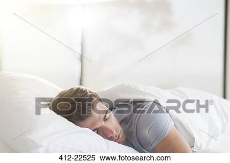 Young man sleeping in bed View Large Photo Image Stock Photography - Young man sleeping in bed. Fotosearch