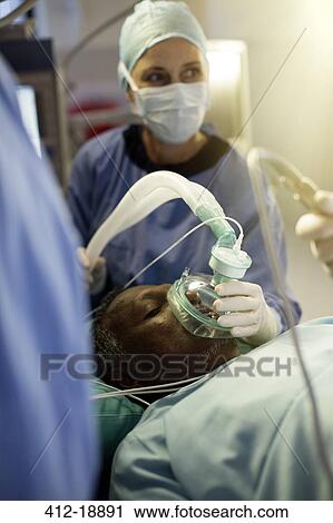 Anesthesiologist holding oxygen mask over patient during surgery View Large Photo Image Stock Image - Anesthesiologist holding oxygen mask over patient during surgery. Fotosearch
