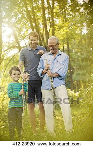 Boy, father and grandfather holding sticks in forest View Large Photo Image Stock Image - Boy, father and grandfather holding sticks in forest. Fotosearch