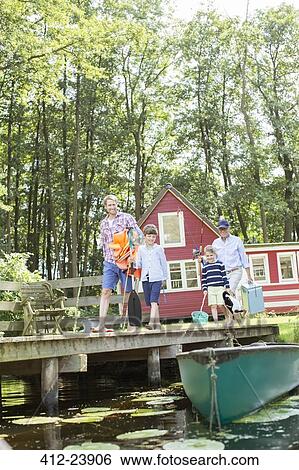 Stock Photograph - Brothers, father and grandfather walking on dock. Fotosearch