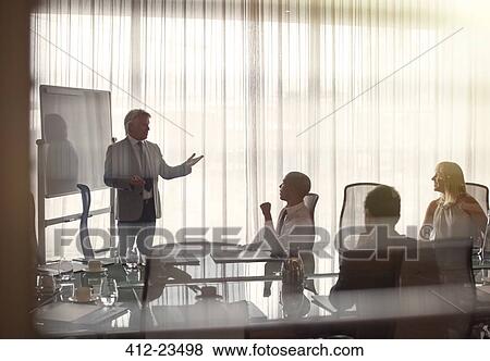 Business people attending presentation in conference room, gesturing and discussing View Large Photo Image Stock Photo - Business people attending presentation in conference room, gesturing and discussing. Fotosearch