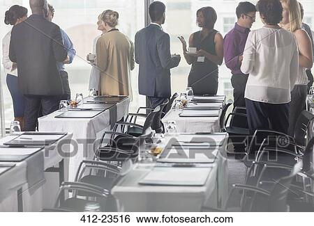Business people holding coffee cups and discussing in conference room View Large Photo Image Stock Photograph - Business people holding coffee cups and discussing in conference room. Fotosearch