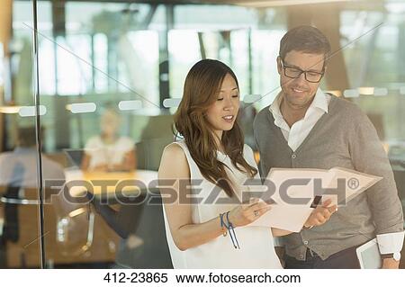 Stock Photography - Business people reading paperwork in office. Fotosearch