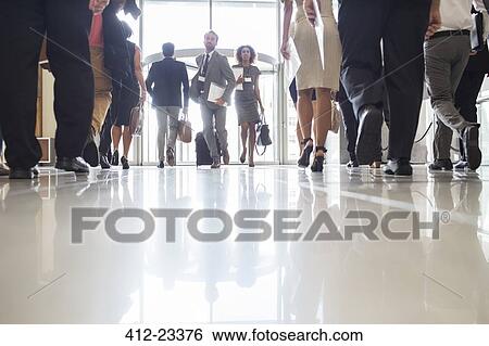 Business people rushing through office hall, reflections on tiled floor View Large Photo Image Stock Photograph - Business people rushing through office hall, reflections on tiled floor. Fotosearch