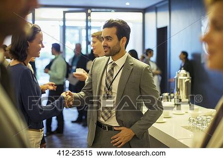 Stock Photography - Business people shaking hands during reception in office. Fotosearch
