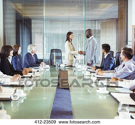 Stock Photo - Business people shaking hands in conference room during business meeting. Fotosearch