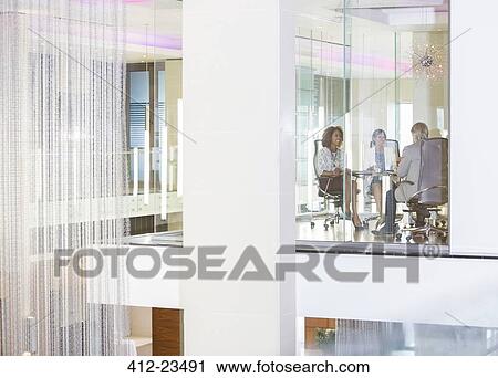Business people sitting in conference room, smiling and talking View Large Photo Image Stock Image - Business people sitting in conference room, smiling and talking. Fotosearch