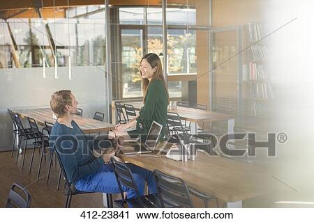 Stock Image - Business people talking in cafeteria. Fotosearch