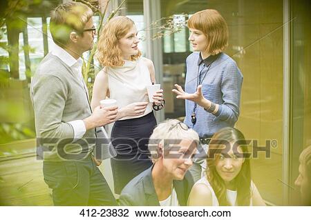 Stock Image - Business people talking in courtyard. Fotosearch