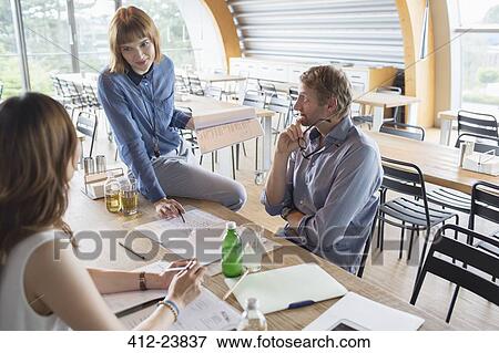 Stock Photo - Business people talking in meeting in cafeteria. Fotosearch
