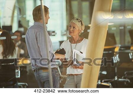 Stock Image - Business people talking in office. Fotosearch