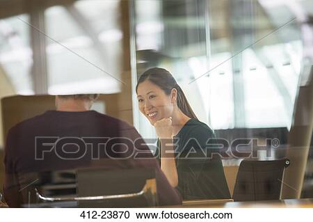 Stock Image - Business people talking in office meeting. Fotosearch