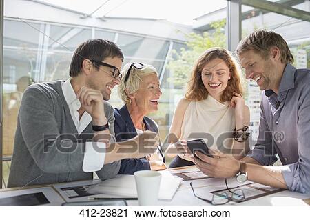 Business people using cell phone in office meeting View Large Photo Image Stock Image - Business people using cell phone in office meeting. Fotosearch