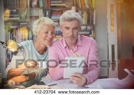 Picture - Business people using digital tablet in home office. Fotosearch