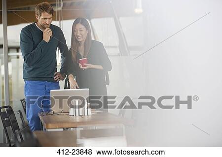 Business people using laptop in cafeteria View Large Photo Image Stock Photo - Business people using laptop in cafeteria. Fotosearch