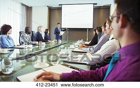 Businessman giving presentation to colleagues in conference room View Large Photo Image Stock Image - Businessman giving presentation to colleagues in conference room. Fotosearch