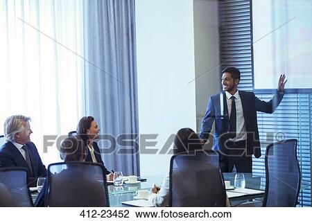 Businessman giving presentation to colleagues in conference room View Large Photo Image Stock Image - Businessman giving presentation to colleagues in conference room. Fotosearch