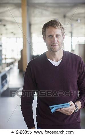 Businessman holding digital tablet in office View Large Photo Image Stock Photography - Businessman holding digital tablet in office. Fotosearch