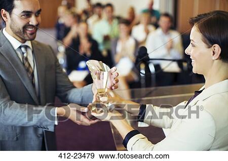 Businessman receiving award from smiling businesswoman View Large Photo Image Stock Photo - Businessman receiving award from smiling businesswoman. Fotosearch