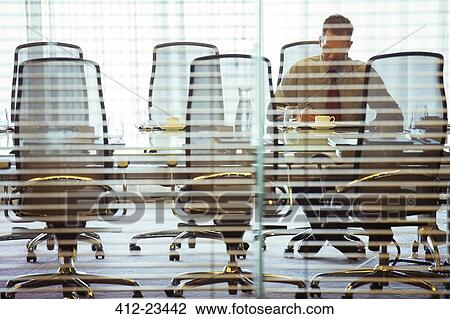 Businessman sitting behind blinds in conference room View Large Photo Image Stock Image - Businessman sitting behind blinds in conference room. Fotosearch