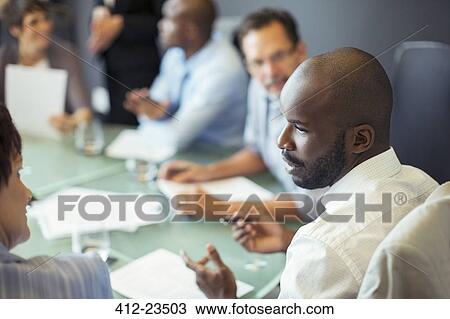 Businessman talking to colleague during business meeting in conference room View Large Photo Image Stock Image - Businessman talking to colleague during business meeting in conference room. Fotosearch
