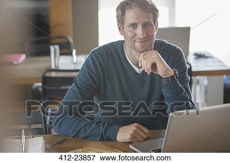 Stock Photo - Businessman using laptop in cafeteria. Fotosearch