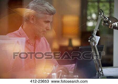 Businessman using laptop in home office View Large Photo Image Stock Image - Businessman using laptop in home office. Fotosearch