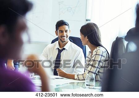 Businesswoman and businessman sitting and talking in conference room during business meeting View Large Photo Image Stock Image - Businesswoman and businessman sitting and talking in conference room during business meeting. Fotosearch