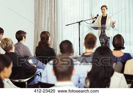 Stock Image - Businesswoman giving presentation in conference room. Fotosearch