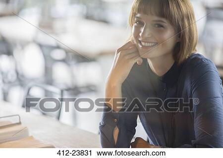 Stock Image - Businesswoman smiling in cafeteria. Fotosearch