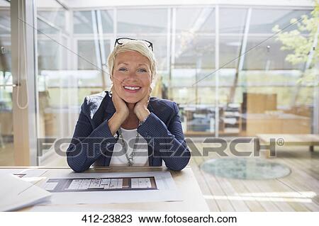 Stock Image - Businesswoman smiling in office. Fotosearch