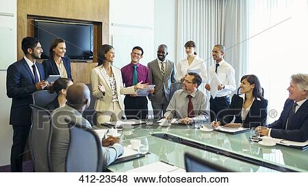 Businesswoman standing at head of conference table and talking View Large Photo Image Stock Photo - Businesswoman standing at head of conference table and talking. Fotosearch